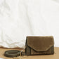 Pochette en velours textile taupe, munie d'une ceinture amovible en cuir pour la passer à la taille, et d'une chaîne dorée pour tout porté épaule. Le Papillon Velvet, par la maroquinerie PÖ&ME à Paris.