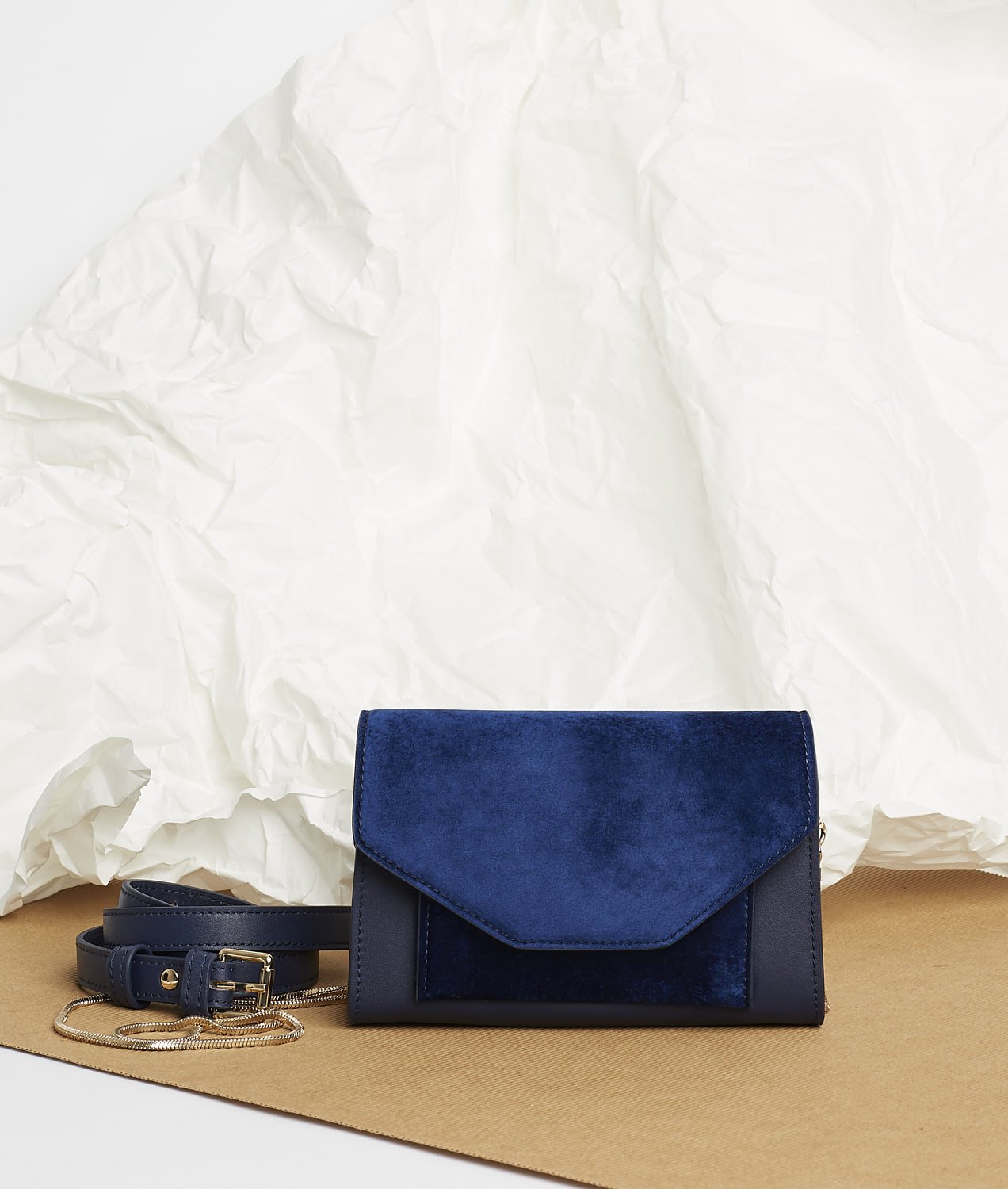 Pochette en velours textile bleu, munie d'une ceinture amovible en cuir pour la passer à la taille, et d'une chaîne dorée pour tout porté épaule. Le Papillon Velvet, par la maroquinerie PÖ&ME à Paris.