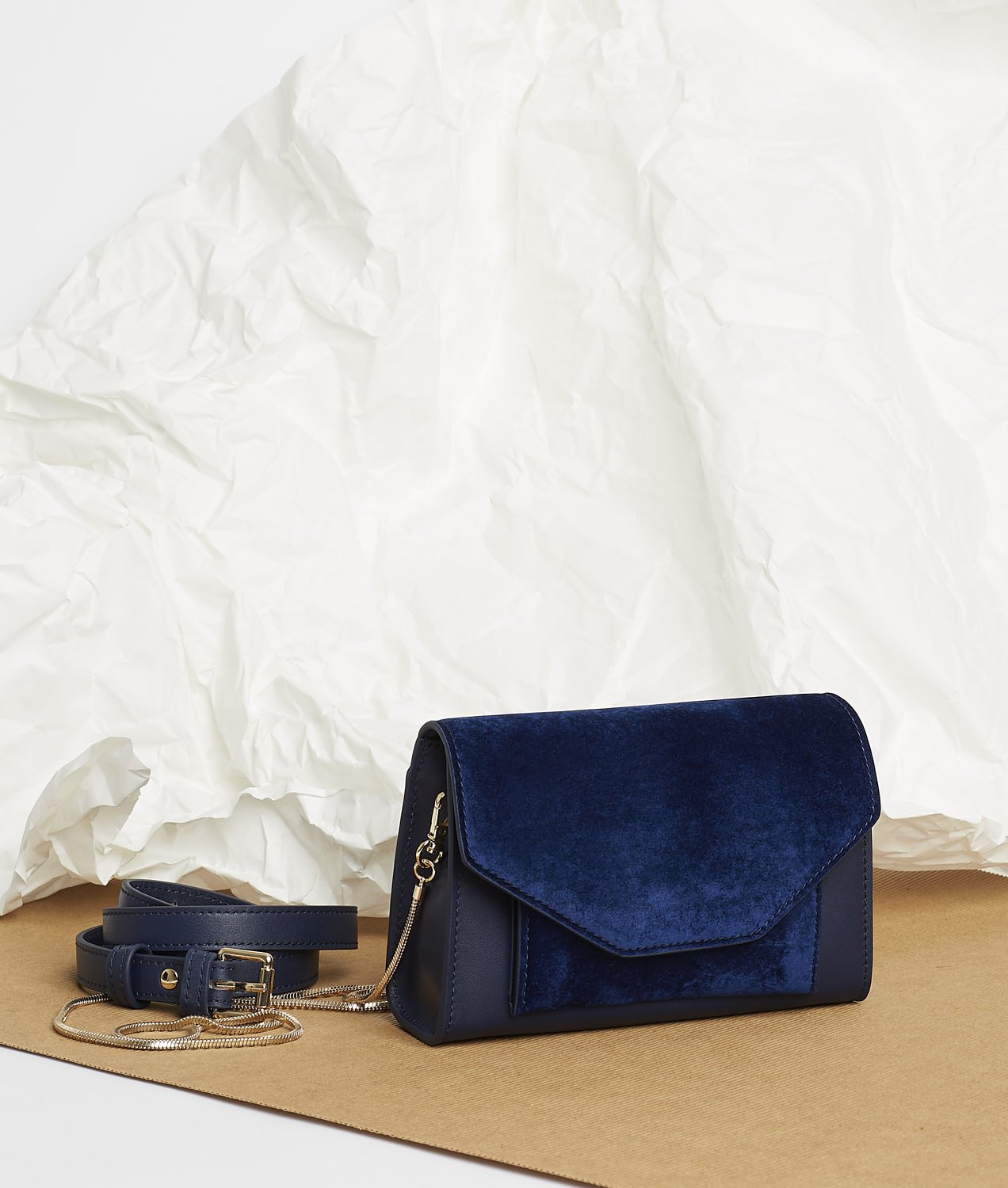 Pochette en velours textile bleu, munie d'une ceinture amovible en cuir pour la passer à la taille, et d'une chaîne dorée pour tout porté épaule. Le Papillon Velvet, par la maroquinerie PÖ&ME à Paris.