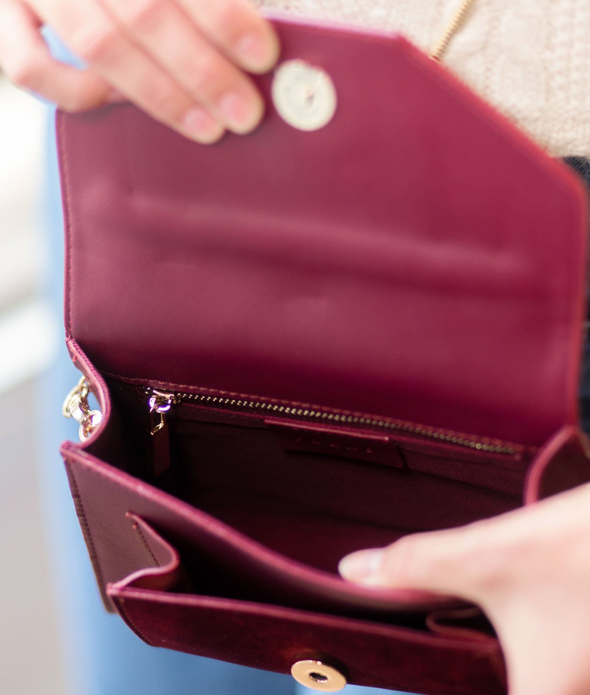 Pochette en velours textile bordeau, munie d'une ceinture amovible en cuir pour la passer à la taille, et d'une chaîne dorée pour tout porté épaule. Le Papillon Velvet, par la maroquinerie PÖ&ME à Paris.